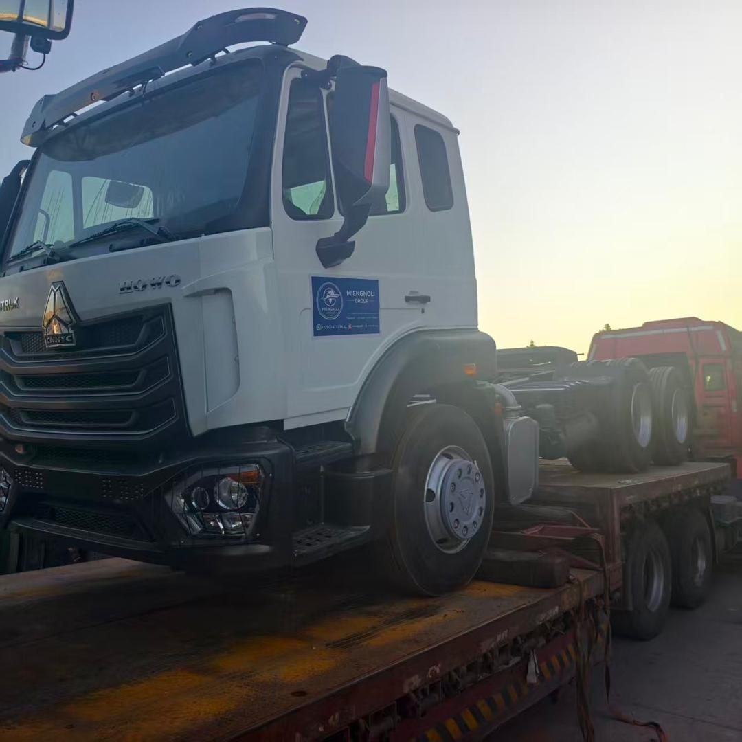 Tracteur routier HOWO aux couleurs de MIENGNOLI GROUP chargé sur un porte-engins