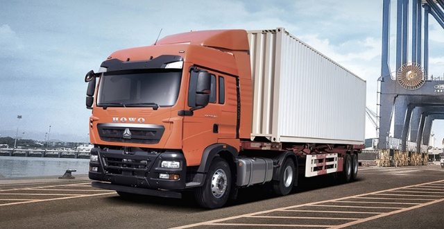 Camion benne chargé de matériaux sur une piste latéritique